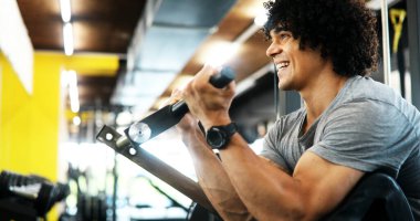 Sağlıklı yaşam ve spor salonu konsepti. Spor fitness kulübünde çalışan zinde bir genç.