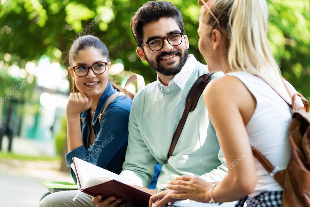 Group of university students studying together and having fun outdoors