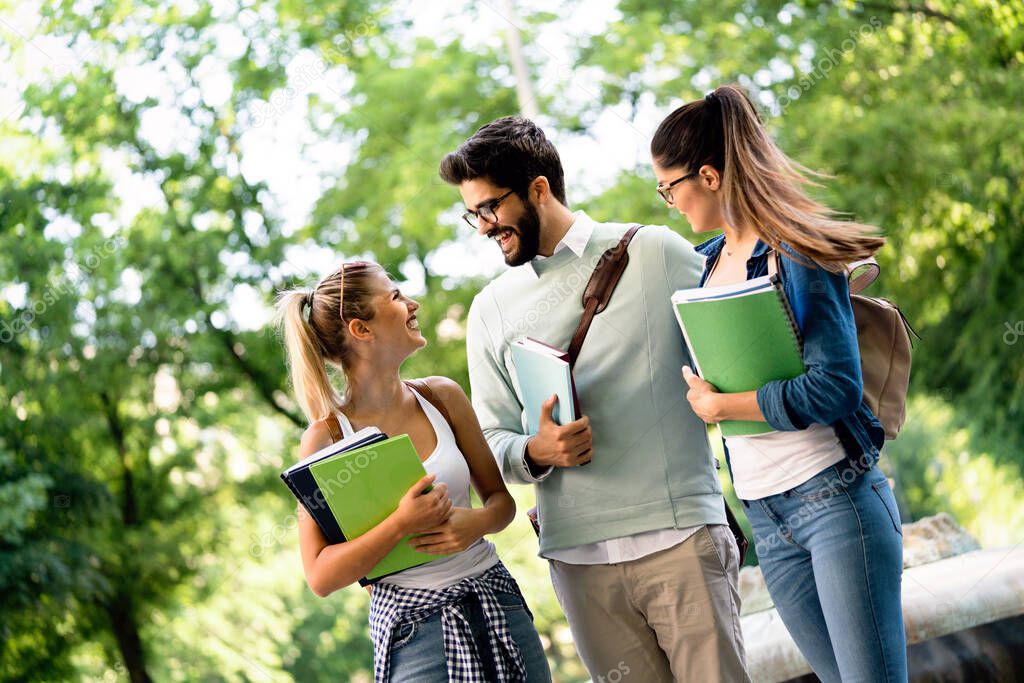 Group of friends or university students smiling, preparing for exam outdoors
