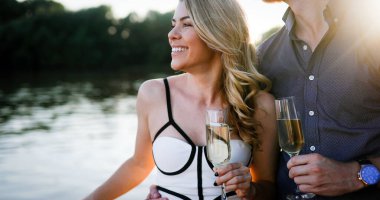 Yaz tatilleri ve flört konsepti. Mutlu güzel romantik çift şampanyayla sarılıyor.