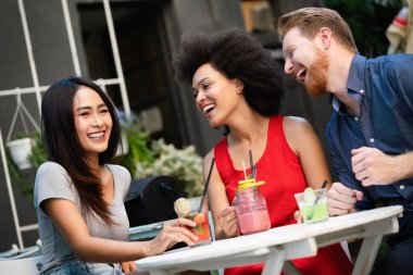 Bir grup arkadaş birlikte eğleniyor. Kadınlar ve erkekler gülüyor ve eğleniyorlar.