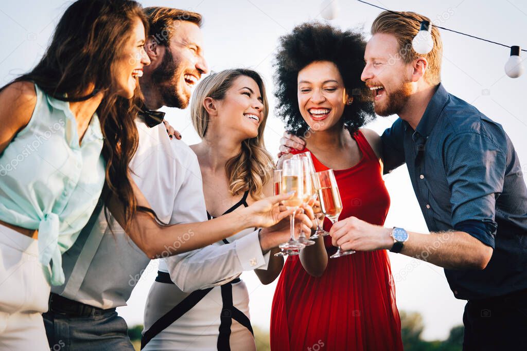 Group of friends partying and toasting drinks. Happy young people with drinks