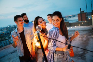 Genç arkadaşlarımla harika vakit geçiriyorum, çatı partisinde eğleniyorum.