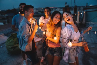 Genç arkadaşlarımla harika vakit geçiriyorum, çatı partisinde eğleniyorum.