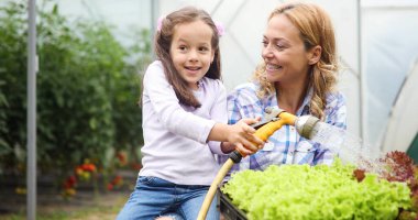 Güzel mutlu anne ve kız çiftlikte, bahçede çalışıyor. Aile, mutluluk konsepti.
