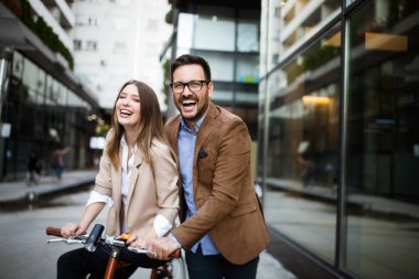 Genç çift şehirde eğleniyor. Bisiklete binen mutlu genç çift