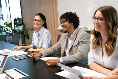 Bir grup iş arkadaşı sunum sırasında toplantı odasında.