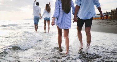 Bir grup arkadaş gün batımında sahilde eğleniyorlar..