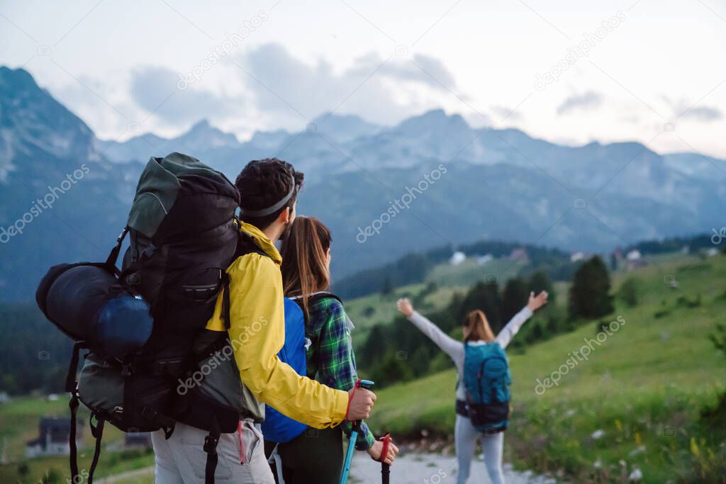 Group of happy friends, people with backpacks hiking together