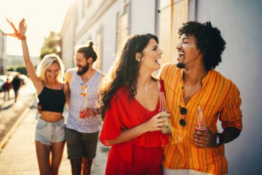 Neşeli bir arkadaş grubu eğleniyor, seyahat ediyor ve gülümsüyor.