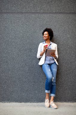 Dışarıda tablet bilgisayarı olan şehirli mutlu iş kadını