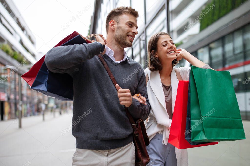 Happy young couple with shopping bags. Sale, travel, love consumerism and people concept.