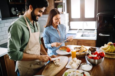 Mutfakta güzel genç bir çift yemek pişiriyor.