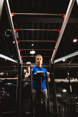 Güzel, uyumlu, mutlu bir kadın spor salonunda bisiklet sürerek antrenman yapıyor.