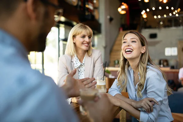 Happy business colleagues having conversation during coffee break