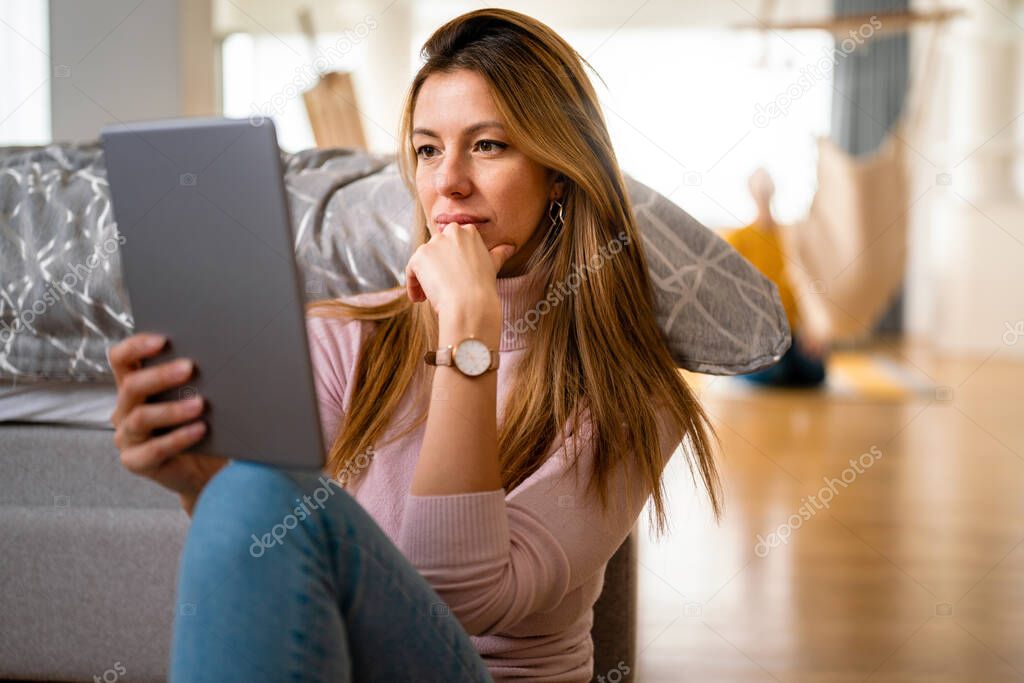 Happy woman using laptop, tablet, computer at home. Technology, people concept