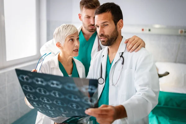 病院でX線を見る患者の診断を議論する医師のグループ — ストック写真