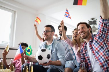 Neşeli ve mutlu bir arkadaş grubu evde televizyonda olimpiyat oyunları izliyor.