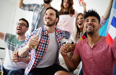 Neşeli ve mutlu bir arkadaş grubu evde televizyonda olimpiyat oyunları izliyor.