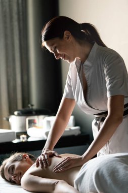 Kaplıca salonunda masaj yaptıran genç bir kadın