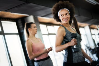 Güzel fit insanlar, spor salonunda birlikte egzersiz yapan arkadaşlar.