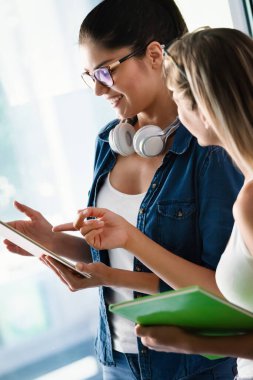 Üniversitede birlikte okuyan ve konuşan mutlu bir öğrenci grubu.