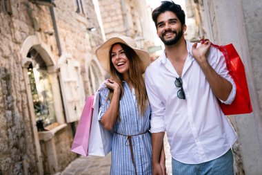 Yaz tatili boyunca şehir sokaklarında gezen ve alışveriş yapan mutlu bir çift.