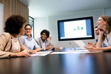 Mutlu iş adamları işyerinde çalışıyor, eğleniyor ve sohbet ediyorlar.