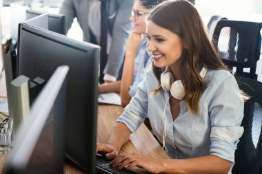 Ofiste çalışan başarılı, mutlu, güzel bir kadın. Teknoloji, bilgisayar, başlangıç, iş konsepti.