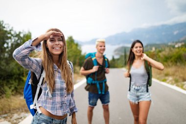 Yazın dışarıda sırt çantalı bir grup mutlu insan.