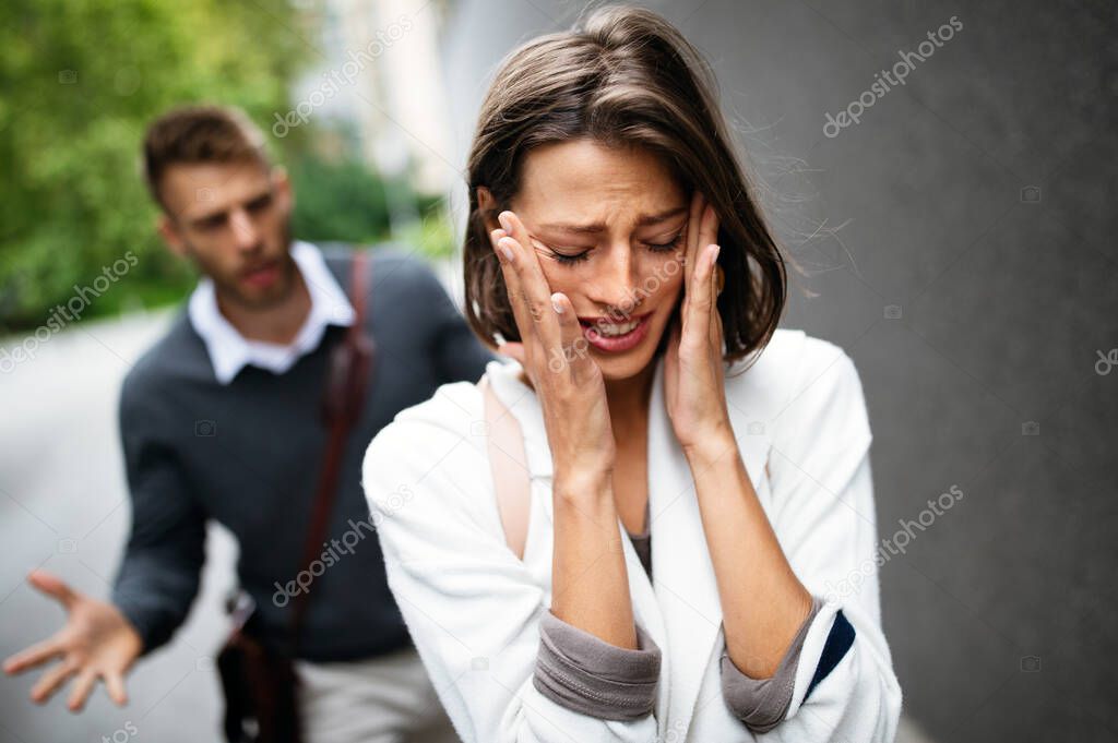 Sad young woman and man outdoor on street having relationship problems, conflicts