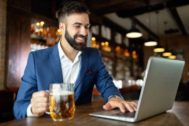 Kafede oturan başarılı bir girişimcinin portresi bir dizüstü bilgisayar üzerinde çalışıyor..