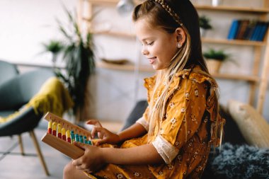 Eğitici tahta oyuncaklarla oynayan güzel bir kız. Sağlıklı mutlu çocuk saymayı öğreniyor.