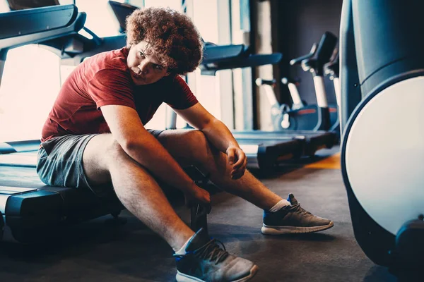 Tired fat young man thinking over weight problems, desire to lose weight, gym workout