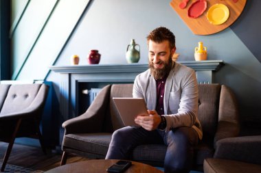 Tablet tutan genç iş adamının portresi çalışıyor, rahatlatıcı.