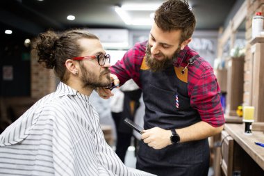 Berber dükkanında sakal tıraşı olan bir müşteri.