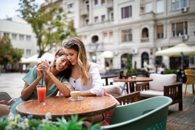 Gerçek arkadaşlar her zaman yakınlardadır. Arkadaşı tarafından teselli edilirken cep telefonu tutan depresyondaki genç bir kadın.