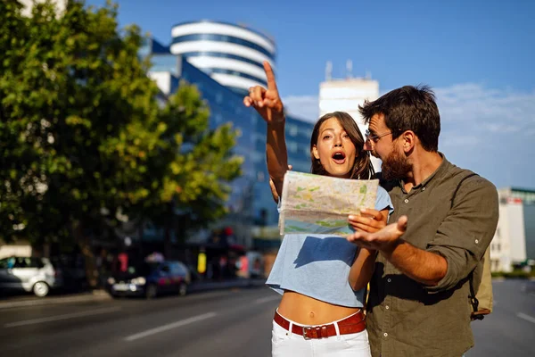 地図付きで楽しい観光都市を持つ休暇中の幸せなカップル — ストック写真