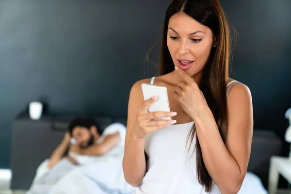 Young Woman Using Cellphone While Her Husband Sleeping Bed Cheating — Stock Photo, Image