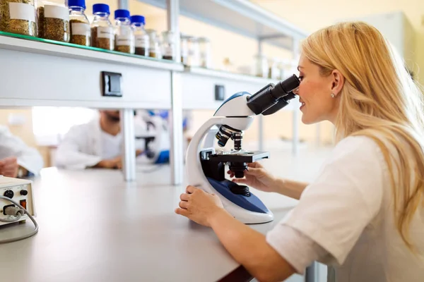 研究室で顕微鏡を使う若い科学者の女性 科学研究者の概念 — ストック写真