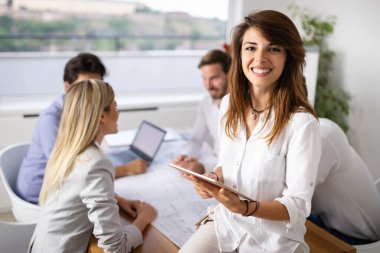 Bir grup iş adamı ofiste buluşuyor, fikir alışverişinde bulunuyor ve fikir paylaşıyor..