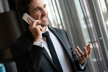 Akıllı telefonunu kullanan mutlu genç bir adam.