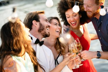 Bir grup mutlu insan ya da arkadaş partide eğleniyor ve gülümsüyor.