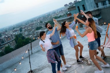 Genç arkadaşlarımla harika vakit geçiriyorum, çatı partisinde eğleniyorum.