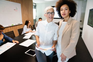 Çok ırklı iş adamlarından oluşan bir grup ofiste toplanıyor.