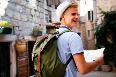 Genç adam yaz tatilinde gülümsüyor ve seyahat ediyor.