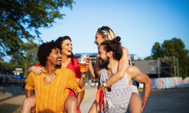 Bir grup mutlu arkadaş müzik festivalinde eğleniyor.