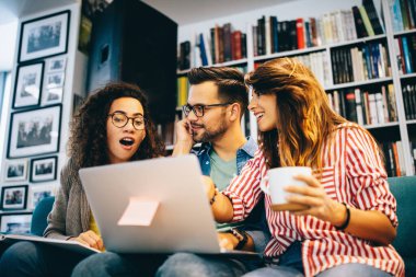 İnsanlar, bilgi, eğitim okulu konsepti. Bir grup mutlu öğrenci kitap okuyor ve kütüphanede sınava hazırlanıyor.