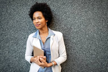 Dışarıda tablet bilgisayarı olan şehirli mutlu iş kadını