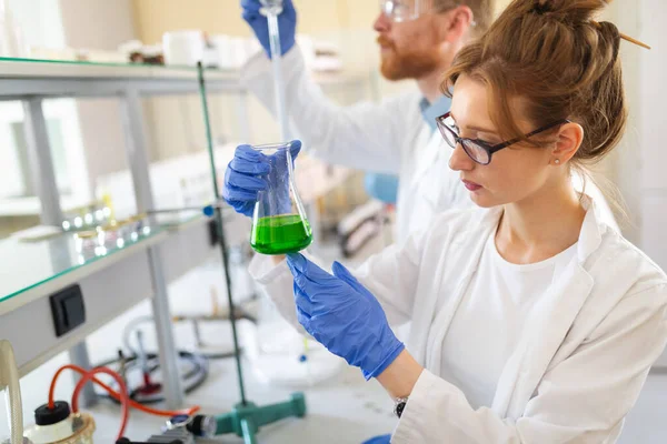 Kadın öğrenci, kimya bilimadamı laboratuarda çalışıyor.